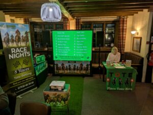 The Halfpint Entertainment Race night set up. This includes are pull up banner for advertising, a face grass floor mat, table set up for the host and screen set up.